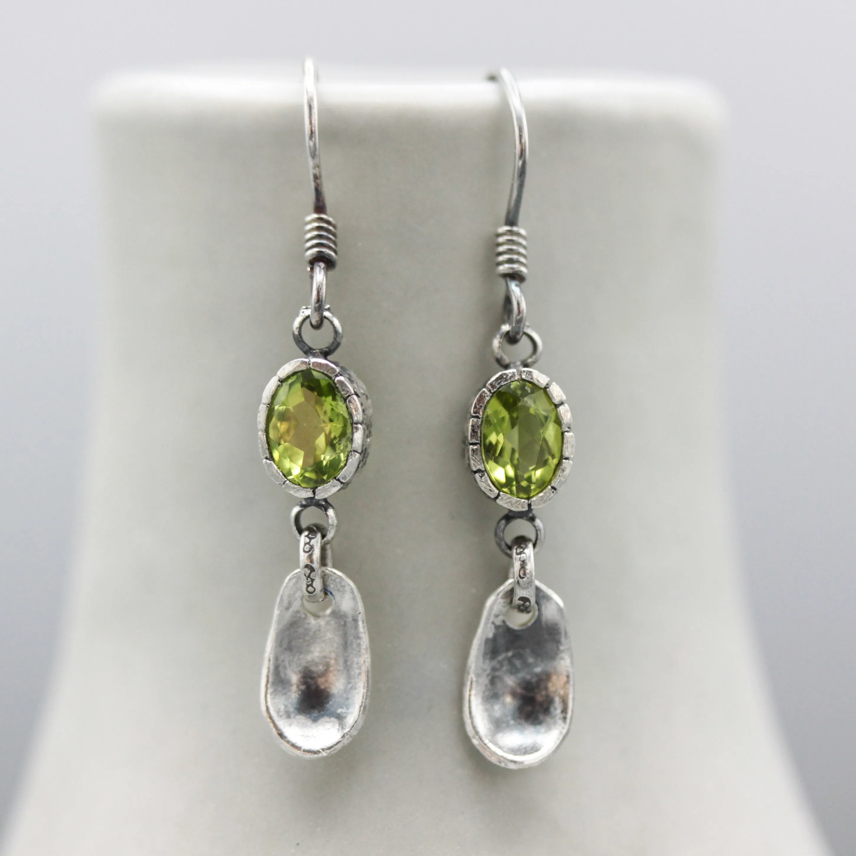 Oval Peridot earrings in silver bezel setting with silver leaf on sterling silver hooks style