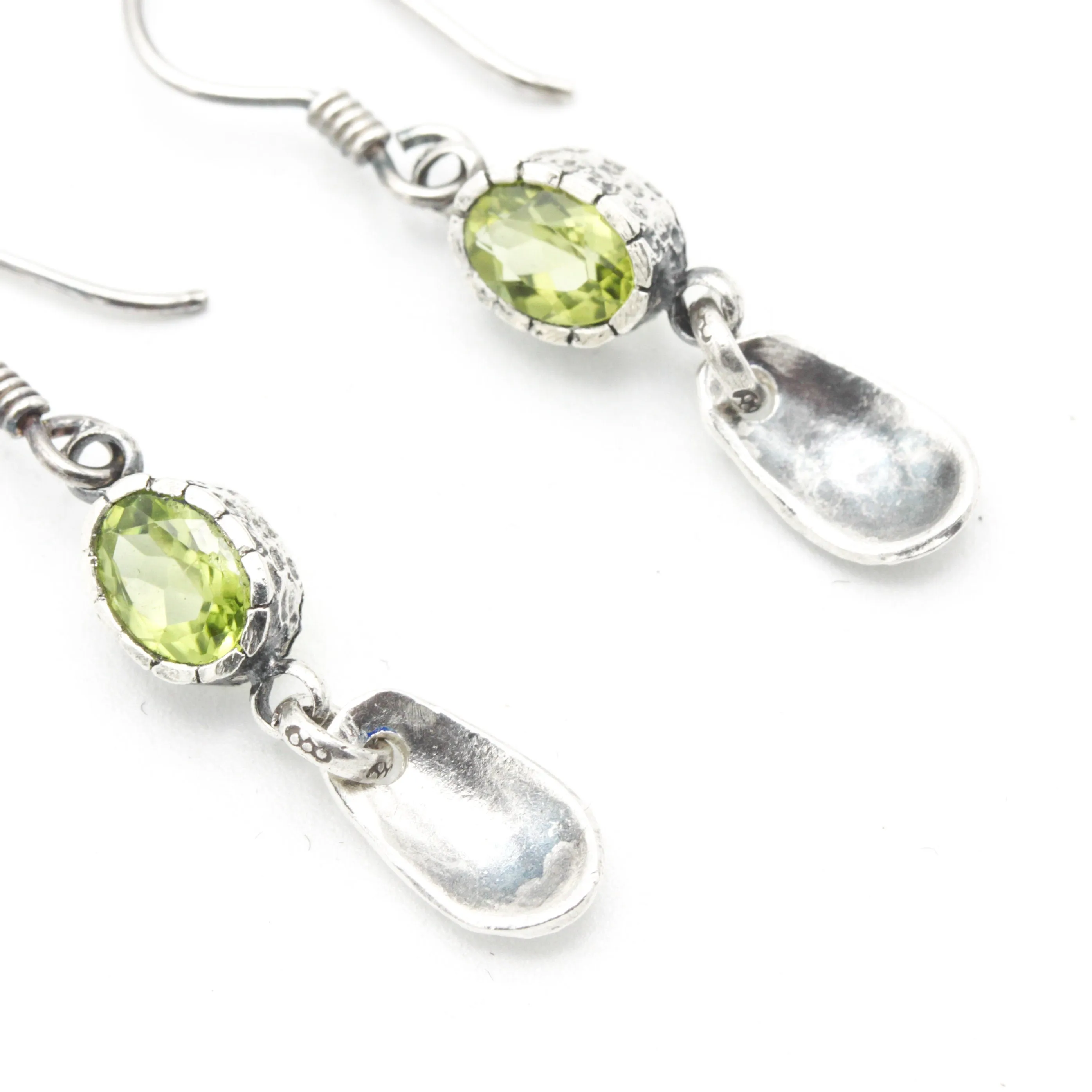 Oval Peridot earrings in silver bezel setting with silver leaf on sterling silver hooks style